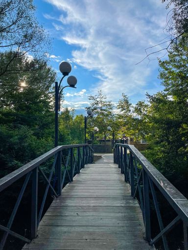 A wooden bridge with a lamp post and street lights