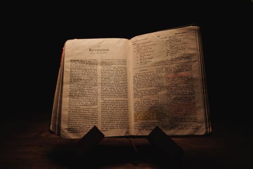 An old Bible book open on the book of Revelation
