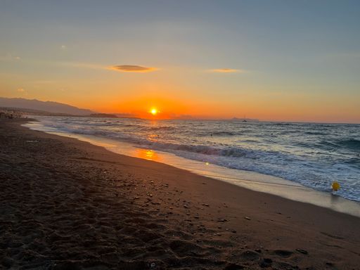 The beautiful orange sunset over the sandy sea shore