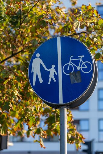 A vertical shot of a blue road pedestrian and bicycle sign