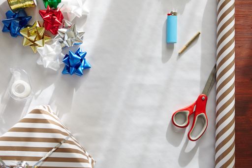A high angle shot of colorful hand-made paper Christmas ornaments in the process of preparation