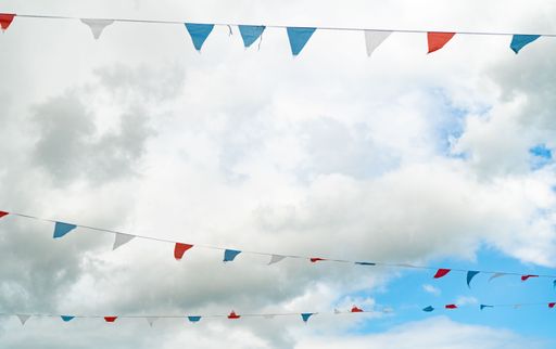 A selective of bunting decorations against the blue sky with white clouds