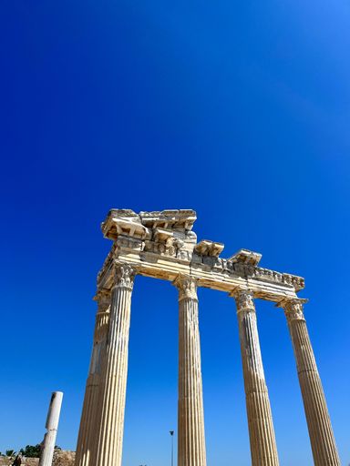 A vertical shot of a damaged historic building with a blue sky in the background