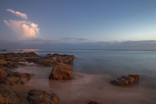 A beautiful view of a beach with big stones  in the evening