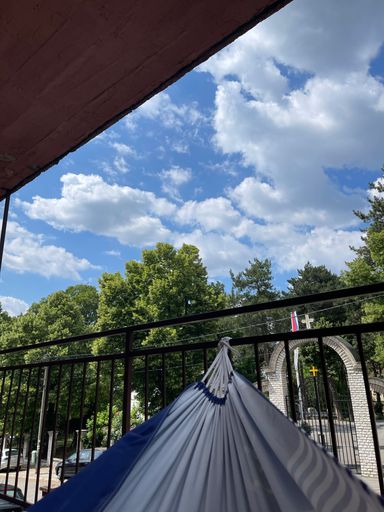 A hammock tied on metal railings under a cloudy