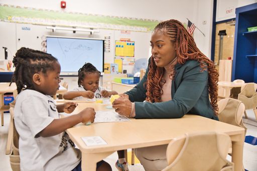 An African American Black teacher teaching young black students in the classroom