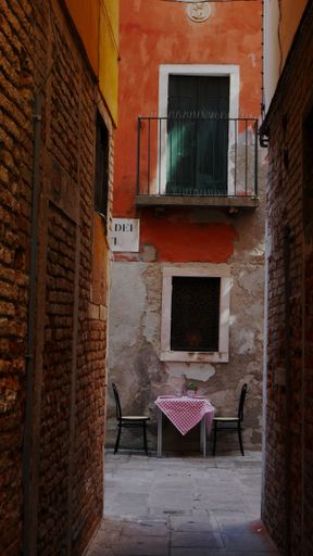 A vertical shot of a table with chairs in front of a building in the town