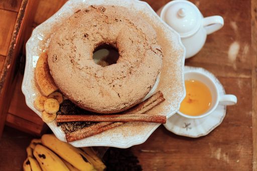 A high angle shot of a delicious Cruller dessert with banana slices and cinnamon