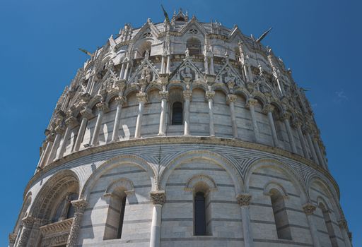 A low-angle shot of the San Giovanni Baptistery in Pisa against a blue sky, Italy