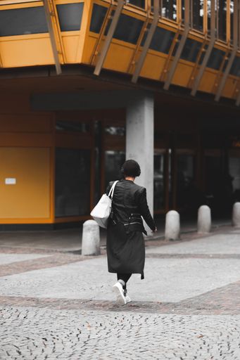 A vertical shot of a woman in headphones walking in the Pforzheim city