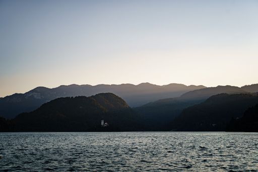 A landscape of Rays of sunset over silhouette mountains on a Bled lake in Slovenia