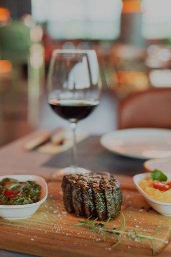A vertical shot of a tasty steak prepared in the ambient of a high class elite steak house restaurant