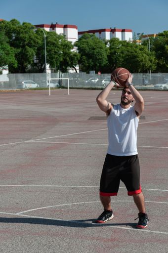 A vertical shot of a sporty Caucasian male playing basketball