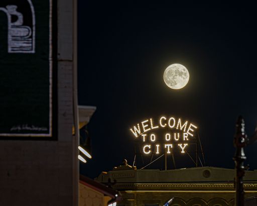 The Full moon rising over New Philadelphia's welcome sign in the USA