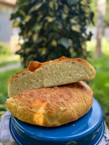 A vertical shot of a homemade bread cut into two pieces