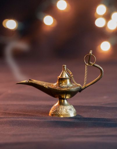 A vertical shot of an old oil lamp with a background of bokeh lights