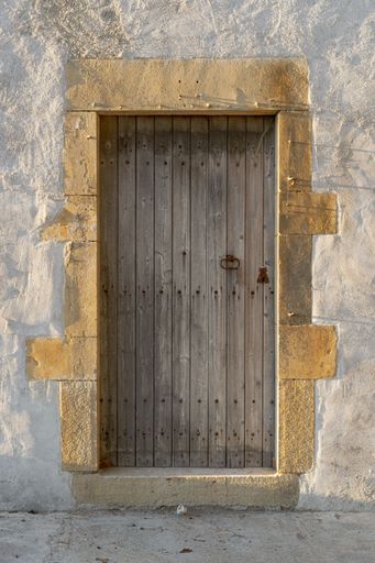A vertical shot of an entrance to the old stone building through the wooden door