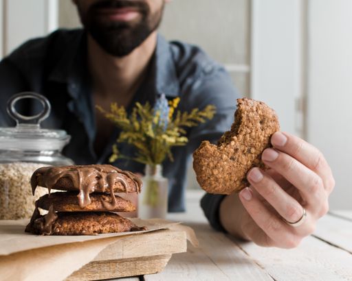 A selective focus shot of a male eating delicious chocolate cookies