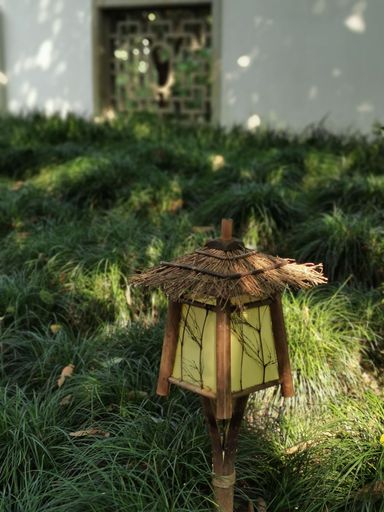 A vertical shot of a garden light installed on the grass of a garden