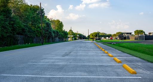 The view of an empty parking lot under the blue sky with clouds