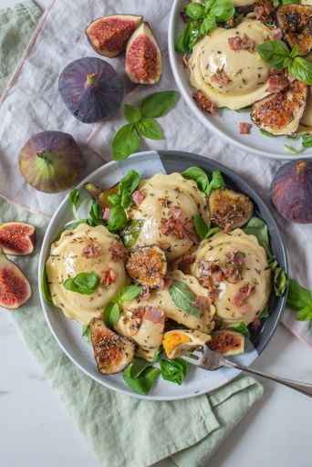 A closeup shot of an Italian dish with pumpkin filled tortellini and cooked fig