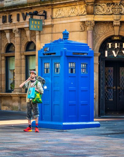 A traveler standing next to an old Police box