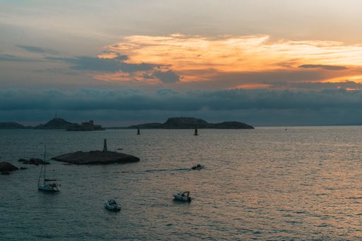 A scenic view of boats on the tranquil sea during a mesmerizing sunset in Marseille, France