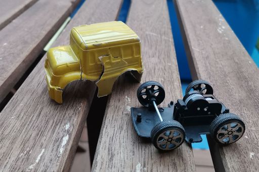 A closeup shot of the broken plastic car on the bench