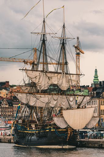 An old wooden ship moored in the picturesque harbor of the bustling city of Stockholm, Sweden.