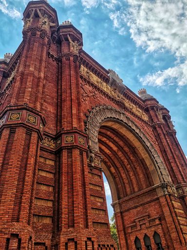A low angle shot of thr The Arc de Triomf in Barcelona, Spain under blue sky