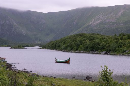 Wonderful landscapes in Norway. Nordland. Beautiful scenery of a valley with a picturesque boat in the Storvatnet lake. Rippled water