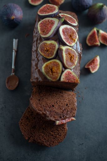A vertical top view shot of a sweet homemade chocolate fig cake on a gray table