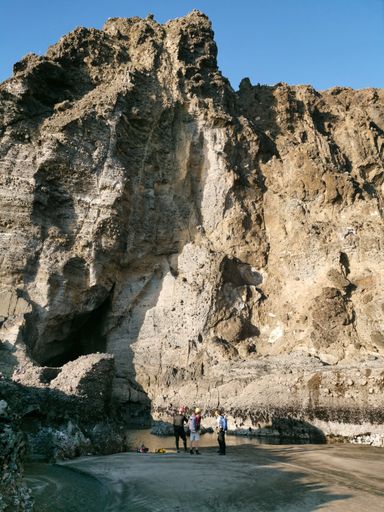 Auckland / New Zealand - April 20 2019: Group of scientists walk around Piha Blowhole cave