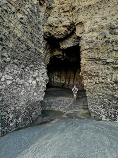 Auckland / New Zealand - April 20 2019: Group of scientists walk around Piha Blowhole cave