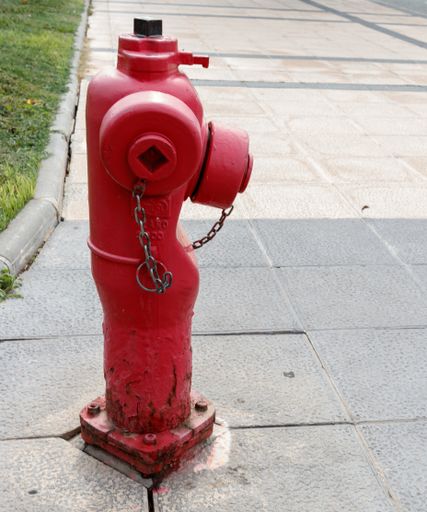 A vertical shot of a fire hydrant on a sidewalk