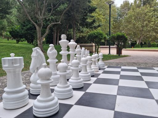 The white pieces of the big outdoor chess set at the park.