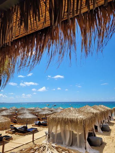 A vertical shot of deck chairs and straw umbrellas on wonderful tropical island in luxury resort
