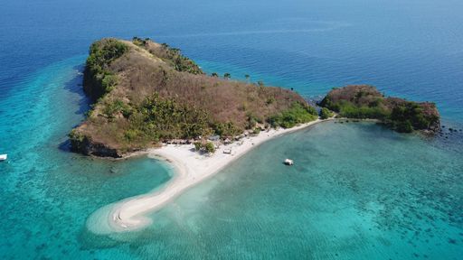 Aerial top view of the scenic seascape, lagoon and coral reef with turquoise water, small waves before storm on island in Philippines