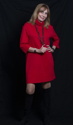 A vertical shot of a Hispanic female with red dress posing on black background