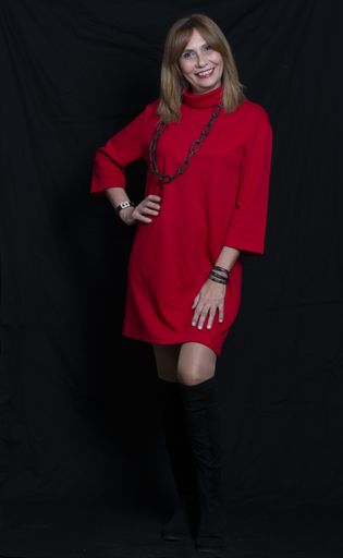 A vertical shot of a Hispanic female with red dress posing on black background
