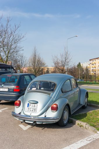 POZNAN, POLAND - APRIL 03, 2016: Parked classic Volkswagen beetle on a parking lot close by apartment buildings