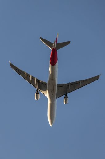 A low angle shot of an airbus jet plane flying in the blue clear sky