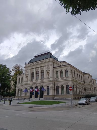 A vertical shot of the National Gallery of Ljubljana under a cloudy sky