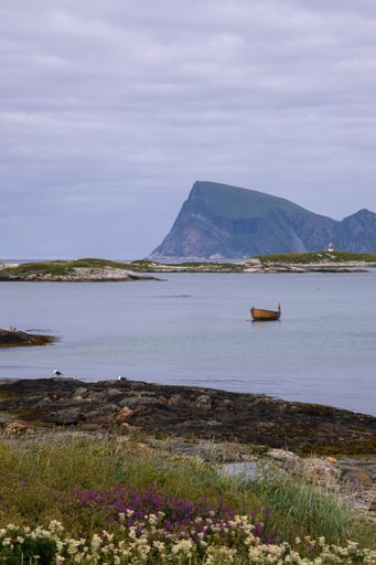 Wonderful landscapes in Norway. Nordland. Beautiful scenery of a boat and a lighthouse on the Sommaroya island. Sea, seagulls and mountain