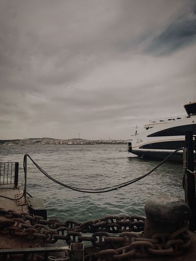 A vertical shot of a ship sailing near the port of Karakoy, Istanbul, Turkey on a cloudy day