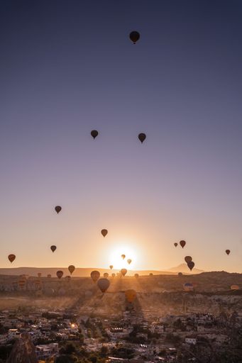 A vertical shot of beautiful hot air balloons at sunset in Cappadocia, Turkiye