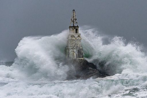 A view of lighthouse during stormy weather on a dark sky background