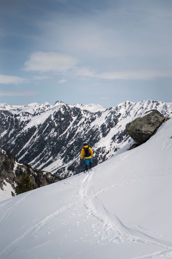 A vertical shot of a man climbing the Pyrenees in winter