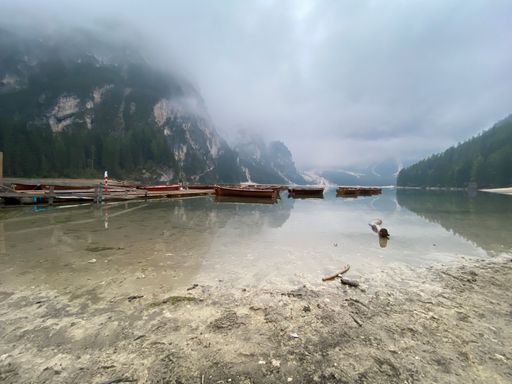 A beautiful shot of a misty sky over the shore of  Braies lake in the Dolomiti mountains in Italy