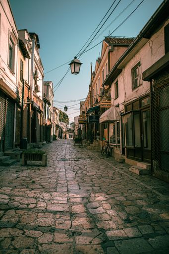A vertical shot of a narrow street surrounded by old buildings in Old Bazaar, Skopje